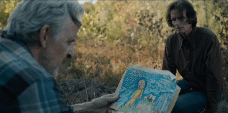 Henry (Robert Joy) studies a disturbing child’s drawing of the Man in Yellow while Victor (Scott McCord) watches in FROM Season 4 Episode 4